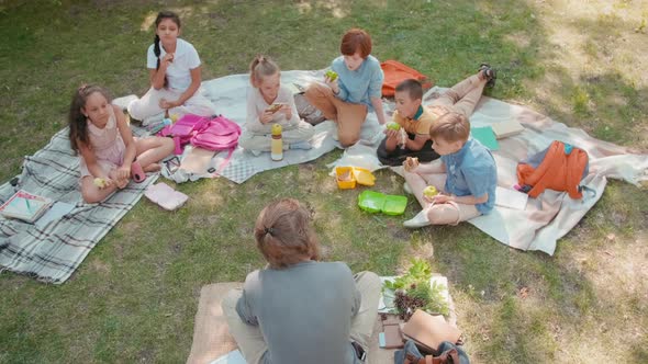 Teacher and Kids Enjoying Lunch Outdoors