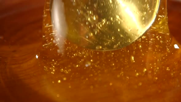 Taking Honey By Metal Spoon in Wooden Bowl, Slow Motion, Macro