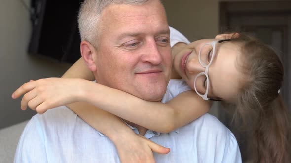 Family Portrait of Mature Father and Little Blonde Daughter Hugging at Home While Celebrating Father