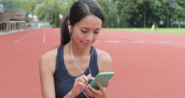 Sport woman listen to music on cellphone in sport arena