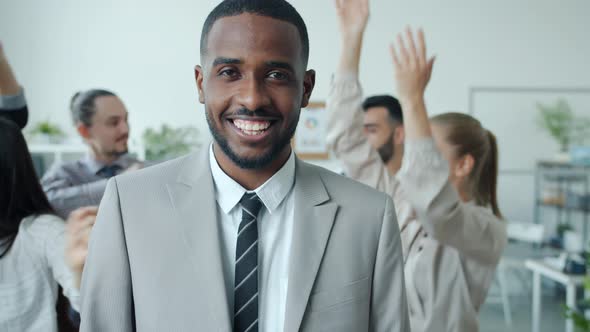 Slow Motion Portrait of AfroAmerican Guy Standing at Business Party with Dancing People Smiling
