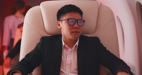 Young Asian Businessman Shocked By Plane Flight in Turbulent Area
