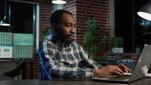 Male Investor Developing Stock Market Statistics on Laptop