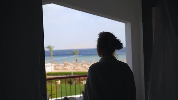 Happy Woman With Arms Wide Open Looking On The Ocean From Resort Balcony