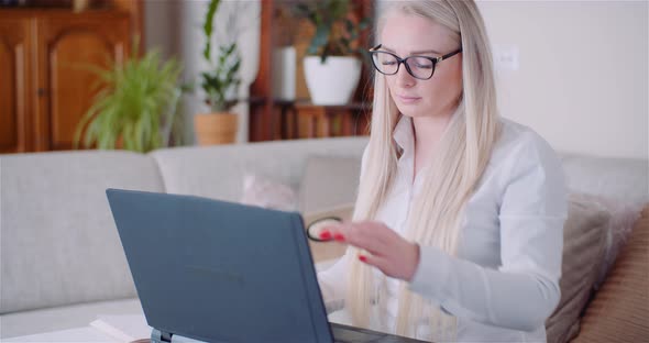 Businesswoman Working on Laptop on a Project at Home Office. Young Woman Using Laptop.