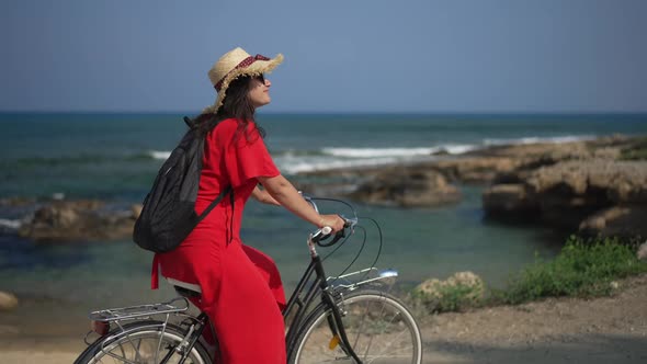 Young Happy Woman Riding Bicycle in Slow Motion Looking Around Smiling