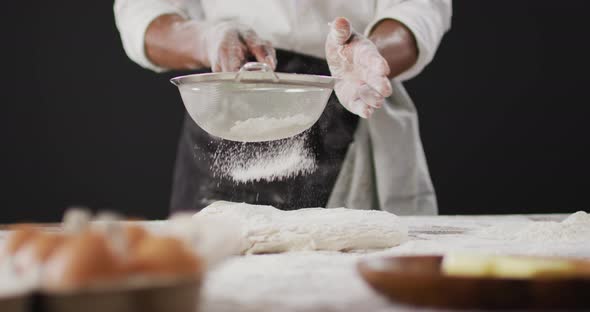 Video of cook throwing flour on the table on black background