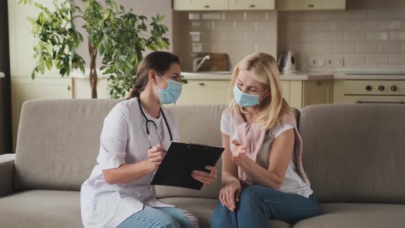 Woman Doctor Help Middle Aged Woman During Homecare Medical Visit with Mask on Face Female Doctor