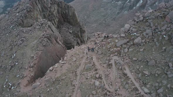 Aerial parallax over hikers on precipice