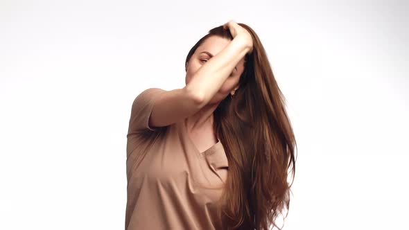 Attractive Woman Smile and Combs Hair with Hand Going Through Them Beautifully Front View