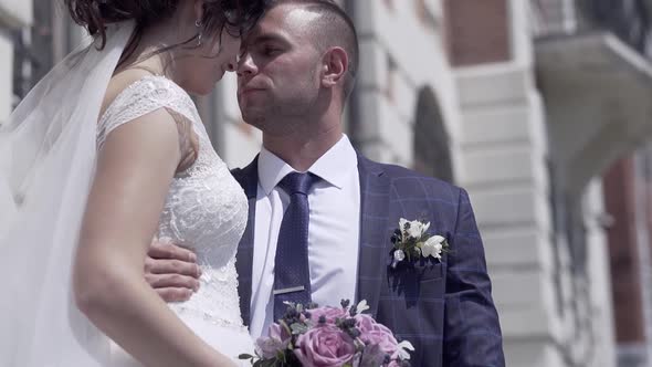 Slow Motion Couple in Celebratory Dressing Hugs Tight