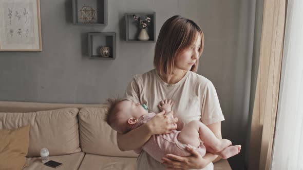 Mother Holding Sleeping Infant at Home