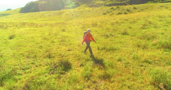 Flight Over Backpack Hiking Tourist Walking Across Green Mountain Field