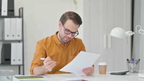 Young Man with Documents Celebrating Success