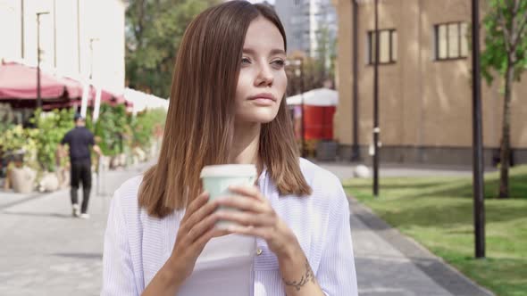 Portrait of pretty young woman walking at the street.