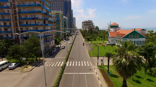 Boulevard with cars between apartment buildings and seafront in Batumi Georgia