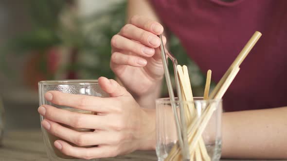 The Girl Puts A Reusable Metal Tube Into A Mug To Drink Coffee. Check Out From Use Of Plastic Tubes.