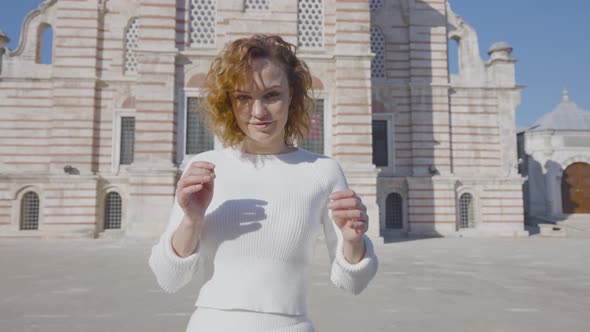 Beautiful woman walks to cathedral in sunny day