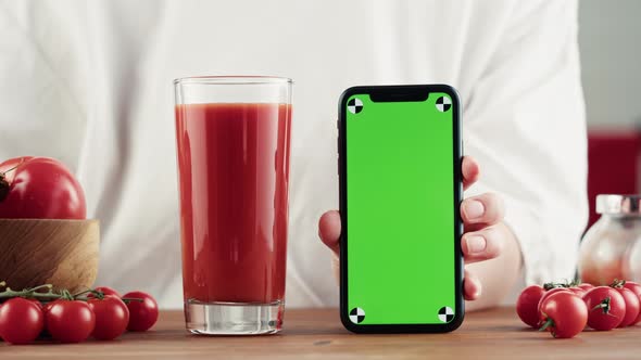 Woman Pouring Tomato Juice and Holding Smartphone with Chroma Key Fresh Red Vegetable Juice on