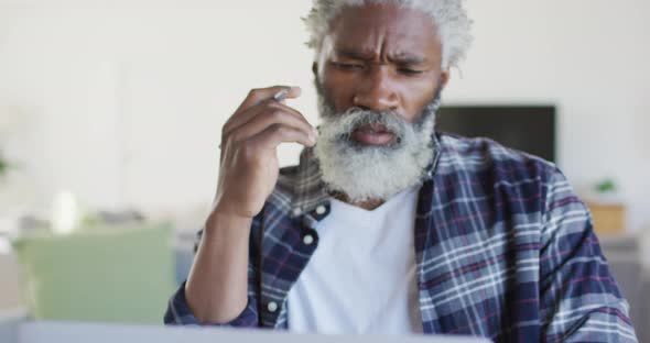 Stressed senior man using laptop at home