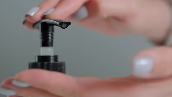 Slow Motion: Woman Pushing Dispenser, Squeezing Out Antiseptic Gel on Palm