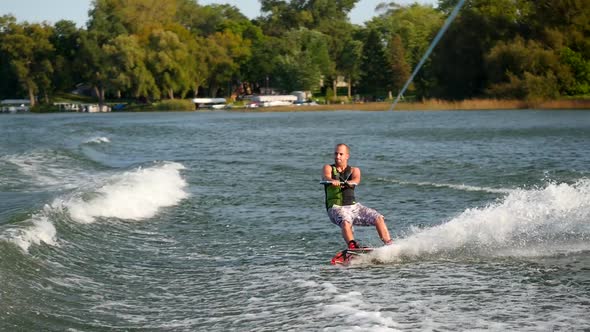 A man wakeboarding behind a boat