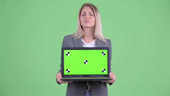 Stressed Young Blonde Businesswoman Showing Laptop