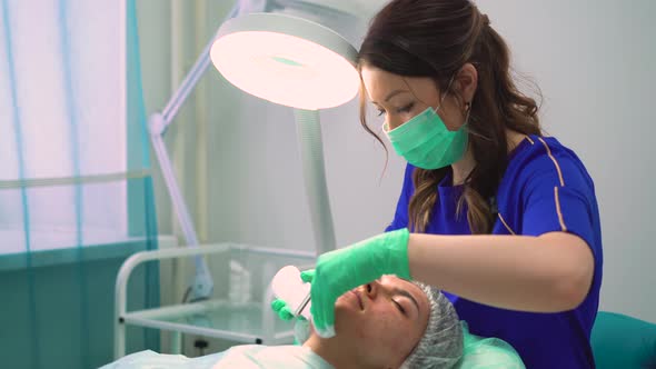 Cosmetologist in Gloves Removes Pimples From Girl Face