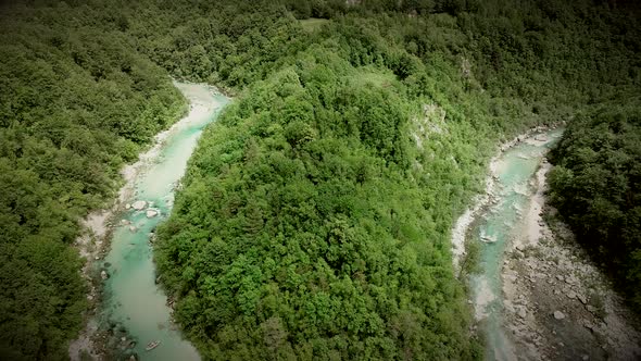 Aerial view of Soca river surrounded by many hills and rocks in Slovenia.