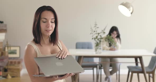 Portrait of a Pretty Caucasian Girl Closing Laptop and Starting Dancing