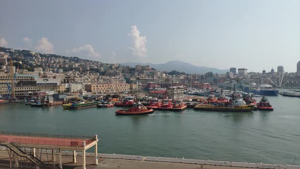 Port of La Spezia, Cinque Terre, Italy. Tugboat sailing backwards into a gap between anchored boats