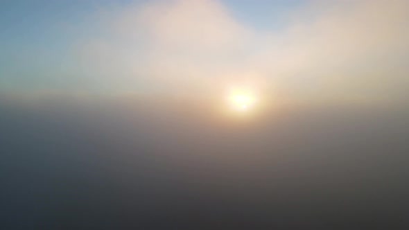 Sunrise Sun Rays in Foggy Hazy Clouds - Aerial Helicopter View