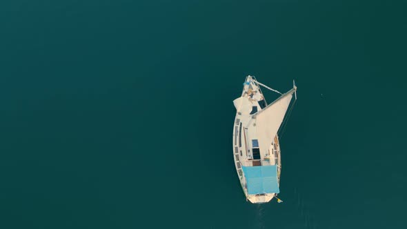 Aerial View on Top Two Young People are Lying on a Yacht and Pouring in the Open Sea