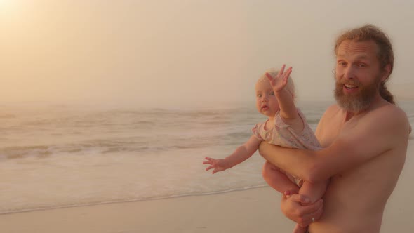 Caucasian Smiling Family Father Carrying Holding Little Baby Infant Small Daughter Son Greeting