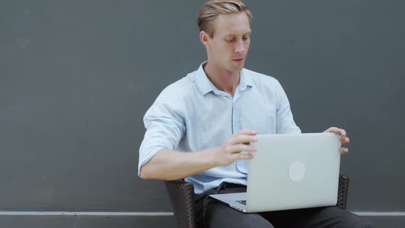 Blond Man Freelancer Examines Laptop Looks at It From All Sides