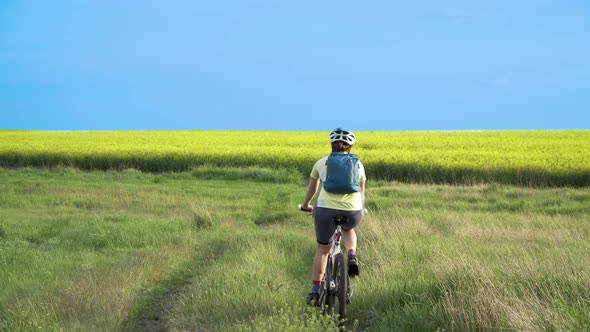 Woman Cyclist Moving On Bike On Countryside