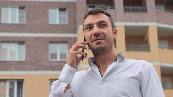 Closeup of a Happy Businessman Talking on the Phone with a Smile