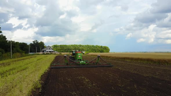 Plow Attached to a Tractor on a Field