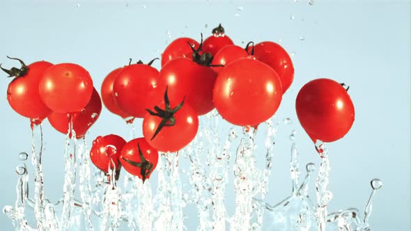 Tomatoes with Splashes of Water Fly Up and Fall Down