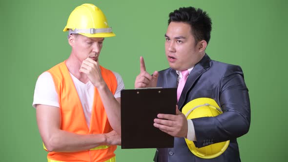 Scandinavian Man Construction Worker and Asian Businessman Working Together