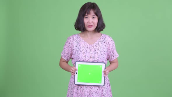 Happy Asian Pregnant Woman Talking While Showing Digital Tablet