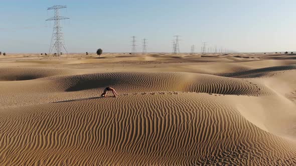 Blonde Athletic Woman is Walking in a Bridge Yoga Pose in the Desert