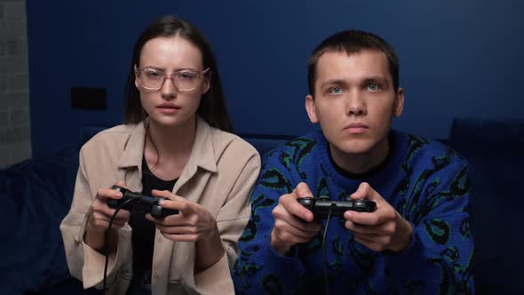 Happy Young People Playing Video Games on Console While Sitting on Couch in Front of Tv. Millennial