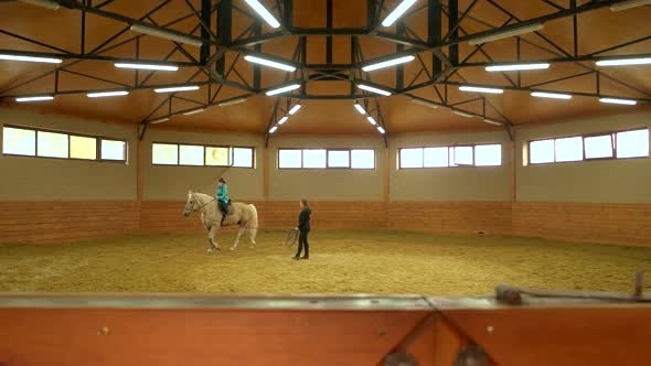 Young Girl Riding Horse Indoors