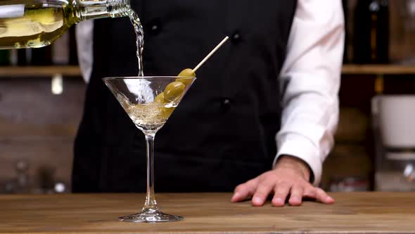 Bartender Pouring Martini in a Cocktail Glass in Slow Motion