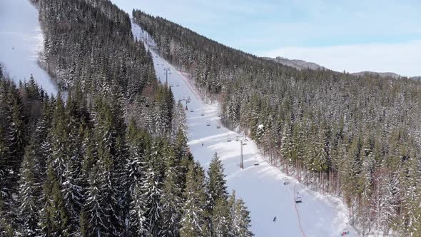 Aerial View of Skiers Go Down Ski Slopes Near Ski Lifts on Ski Resort. Bukovel