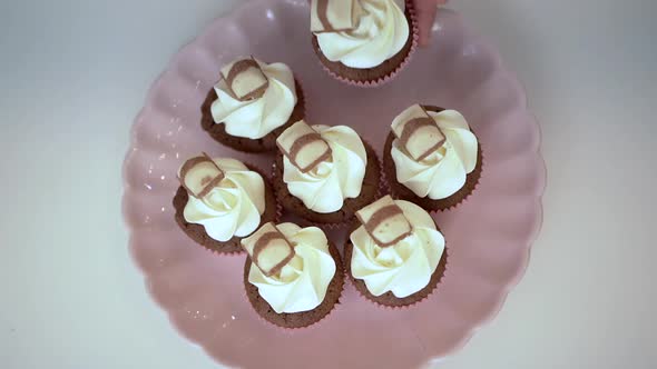 Woman arranging cupcakes on plate