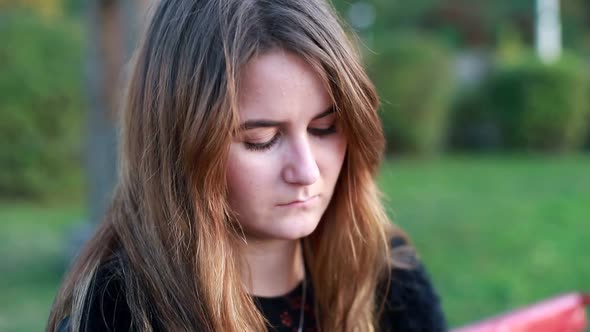 Sad woman, upset girl in park, girl looking away while avoiding gaze