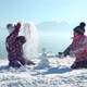 Cheerful Little Girls in Outwear Having Fun and Throwing Snow in Sunlight Standing Outdoors - VideoHive Item for Sale