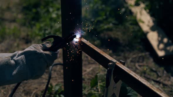 Closeup Repairman Uses Equipment for Welding Fence Carcass